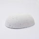 A half egg shaped pastel in a white tone, sitting on a white background