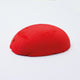 A half egg shaped pastel in an intense red tone, sitting on a white background