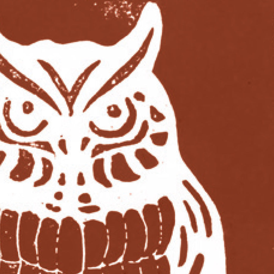 A printed linocut of an owl in brown ink with the outline of the owl appearing in white.