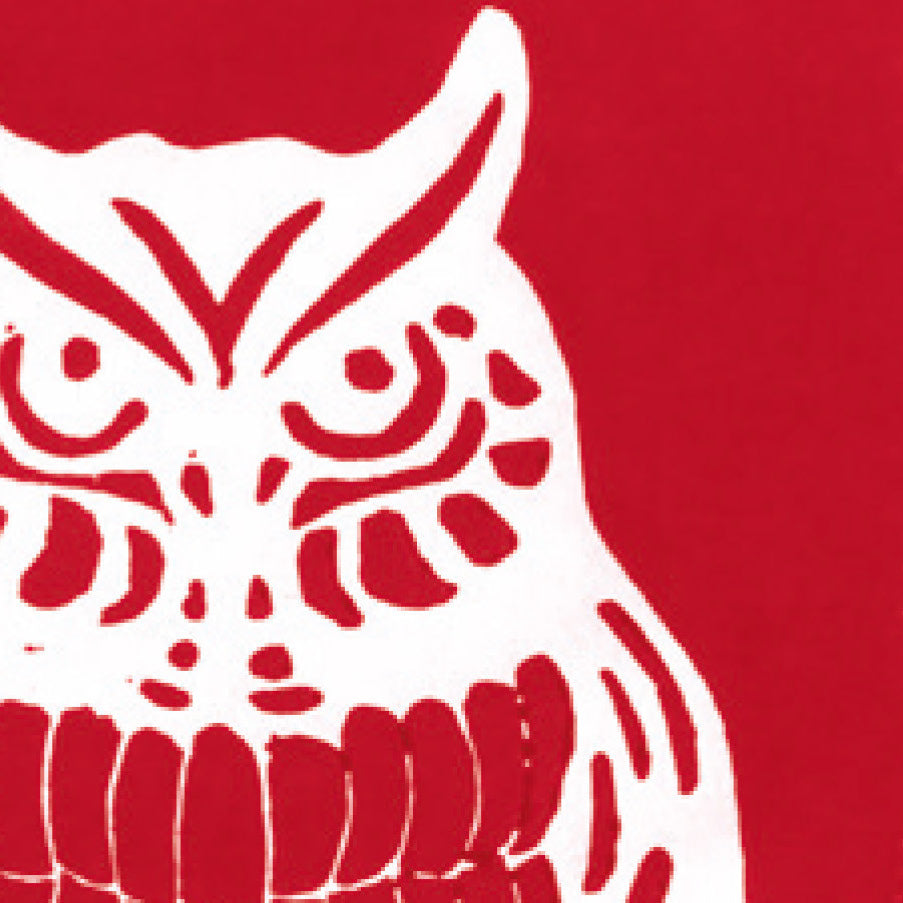 A printed linocut of an owl in red ink with the outline of the owl appearing in white.