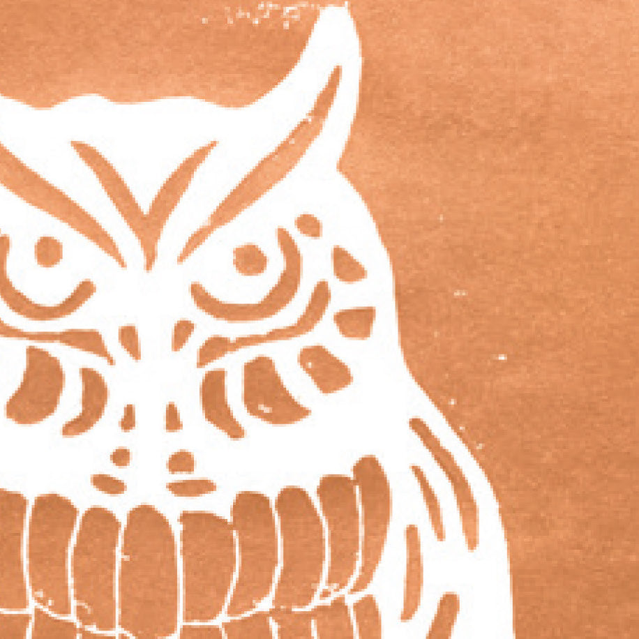 A printed linocut of an owl in copper ink with the outline of the owl appearing in white.