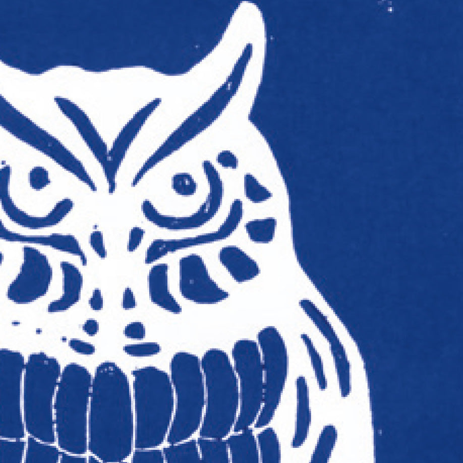 A printed linocut of an owl in blue ink with the outline of the owl appearing in white.