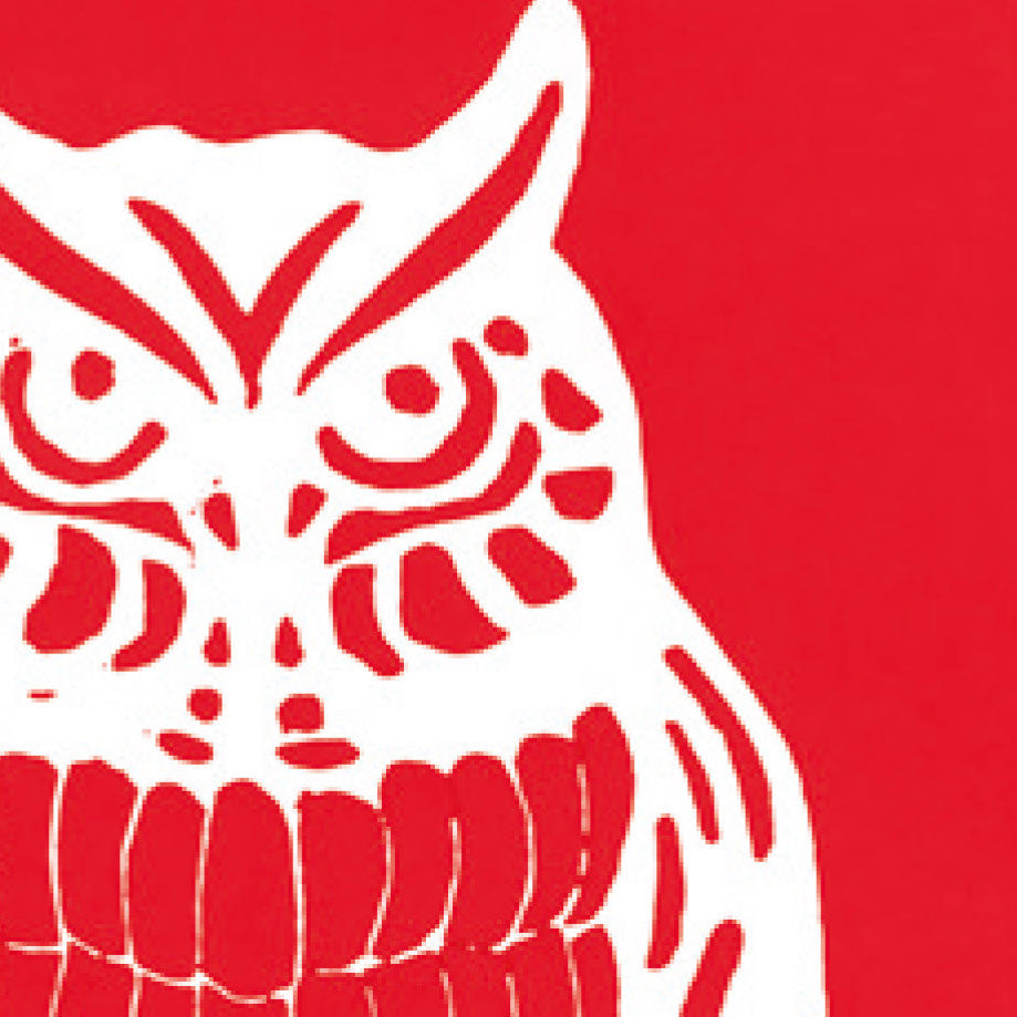 A printed linocut of an owl in red ink with the outline of the owl appearing in white.
