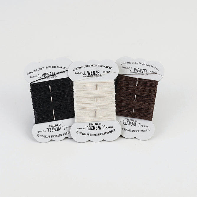 Three spools of Wenzel waxed linen thread in black, white, and brown colours, placed side by side on a white background.